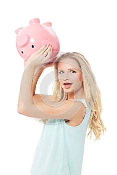 Woman, piggy bank and finance or surprised in studio with cash investment, financial growth or wealth. Person, money box