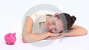 Woman with a piggy bank resting on a table