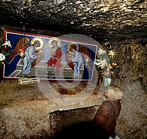 Woman pilgrim is praying in prison of Jesus Christ.