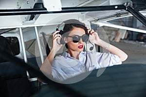 Woman pilot in headset ready to fly in small airplane