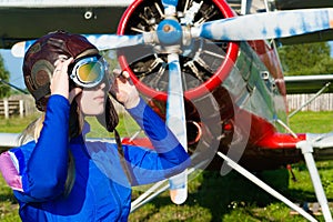 Woman pilot in helmet on background of airplane