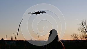 Woman piloting a drone at sunset