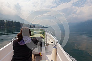 Woman piloting motor boat on a smooth, peaceful, beautiful