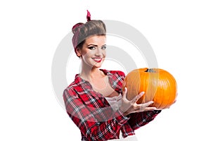 Woman with pin-up hairstyle holding orange pumpkin. Autumn harvest