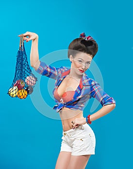 Woman with pin-up make-up with a bag of fruit