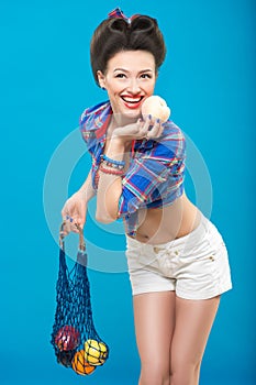 Woman with pin-up make-up with a bag of fruit