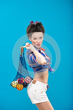 Woman with pin-up make-up with a bag of fruit