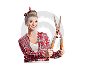 Woman with pin-up make-up and hairstyle holding pruning shears