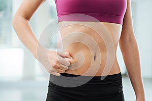Woman pinching fat on her belly