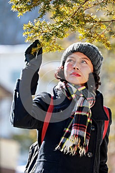 Woman and the pine leaves with sunshine background. Autumn season concept