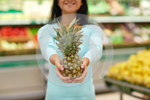 Woman with pineapple at grocery store