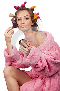 Woman in pink bath robe making-up