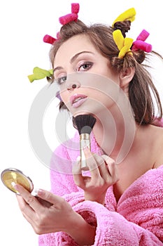 Woman in pink bath robe making-up