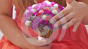 Woman in pink dress holding bridal bouquet in hands close-up. Wedding purple red white flowers bunch.Wedding decorations