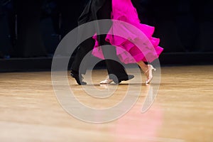 Woman in pink gown and man black tailcoat. Latino dancing