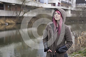 Woman with pink hair in bleak surroundings