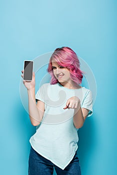 Woman with pink hair holding smartphone