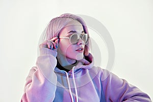Woman with pink hair in sunglasses on white background