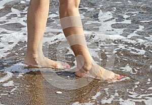 Woman with pink nailpolish walking on the beach