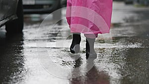 Woman with a pink raincoat a walk through the city on a rainy day.