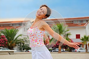 Woman in pink shirt spinning on beach