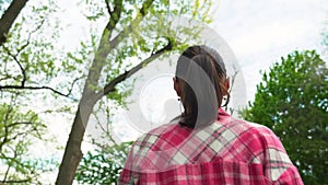 Woman in pink shirt walking on ancient stair back view.