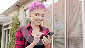 Woman with Pink Short Hair Using a Phone in Town