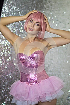 Woman in a pink wig with short hair on a silver shiny background