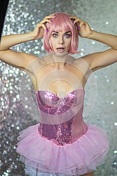 Woman in a pink wig with short hair on a silver shiny background