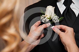 A Woman Pinning A Boutonniere photo