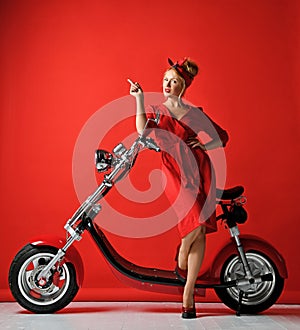 Woman pinup style ride new electric car motorcycle bicycle scooter present for new year 2019 pointing finger up