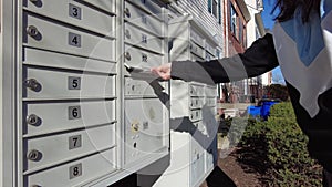 A woman places a mail to the outgoing mailbox of her condo