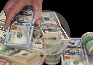 Woman placing banknotes on a pile of bundles