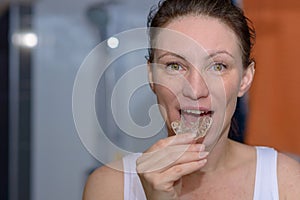 Woman placing a bite plate in her mouth photo