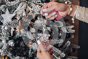 Woman placing Christmas toy on the tree