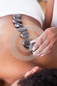 Woman Placing Lastone On Man Back