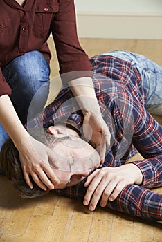 Woman Placing Man In Recovery Position After Accident photo
