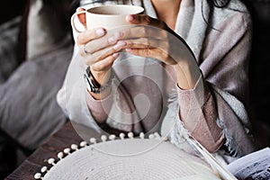 woman in a plaid holds a mug. Beautiful female hands. A cup of tea or coffee