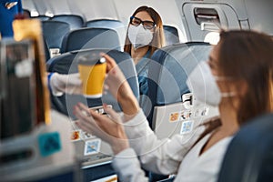 Woman from plane front seat looking at stewardess, passing coffee