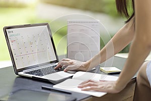 Woman planning agenda and schedule using calendar event planner.