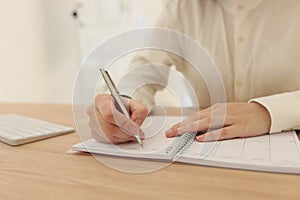 Woman planning business and taking notes in office