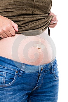 Woman with plaster on her belly