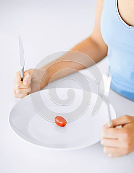 Woman with plate and one tomato