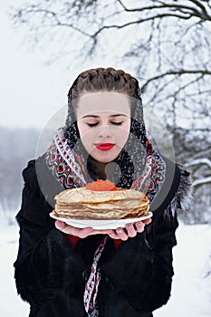 Woman with a plate of pancakes and red caviar