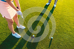 Woman player ready to hit the ball into the hole at the end of a