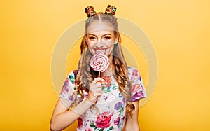 Woman with playful look lick candy with tongue