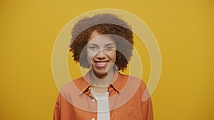 Woman in Playful Mood Looking At Camera on Yellow Background