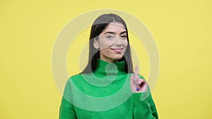 Woman Playfully Waving Finger In Disagree Over Yellow Background