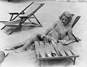 Woman playing backgammon on beach photo