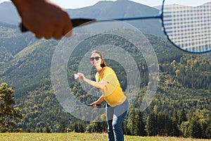 Woman playing badminton in mountains on sunny day